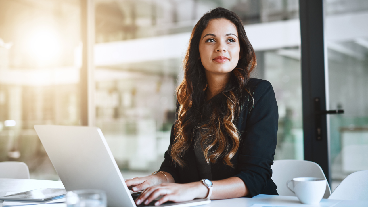 A smiling woman sitting at her laptop