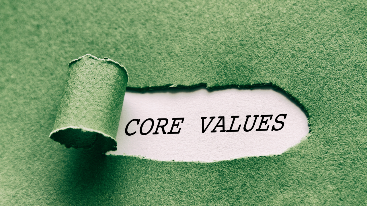 A green piece of paper is torn away to reveal the text "CORE VALUES"
