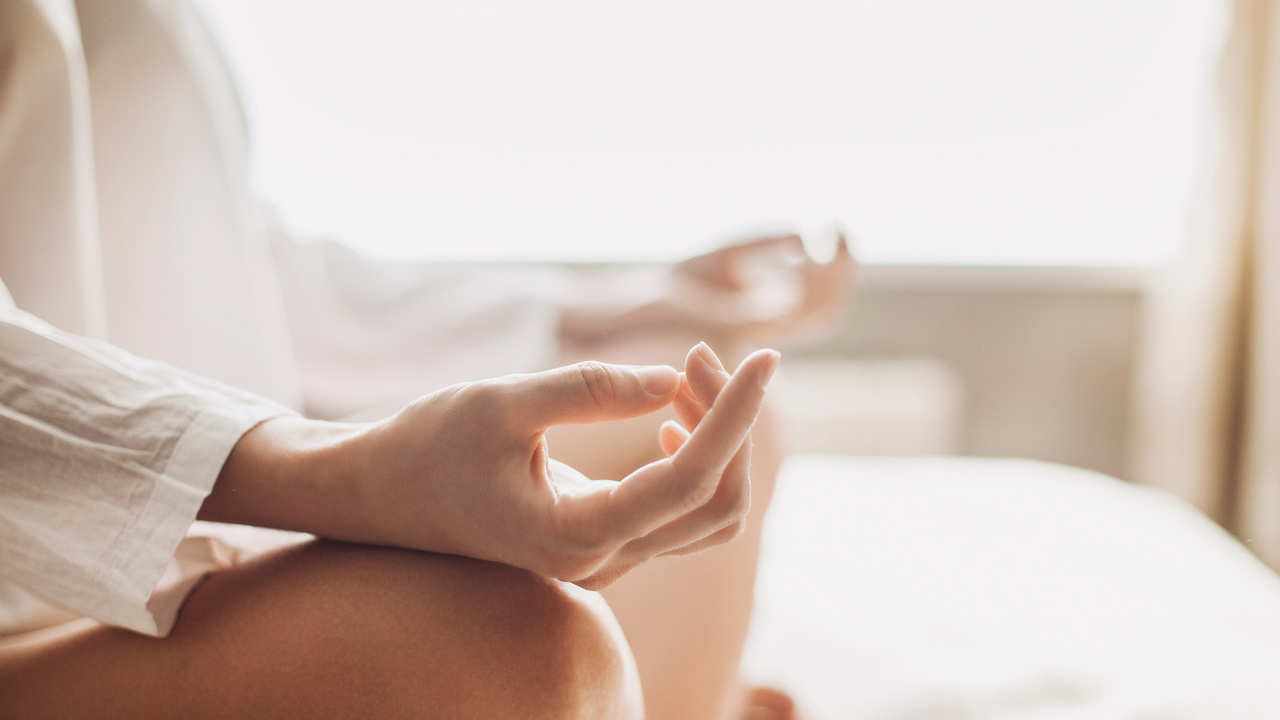 The hands of a woman in the "ohm" meditation position